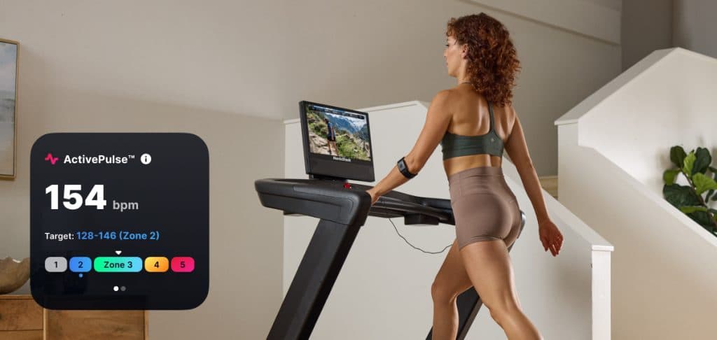 User walking on a NordicTrack treadmill while ActivePulse™ automatically adjusts speed and incline to maintain a target heart rate zone.