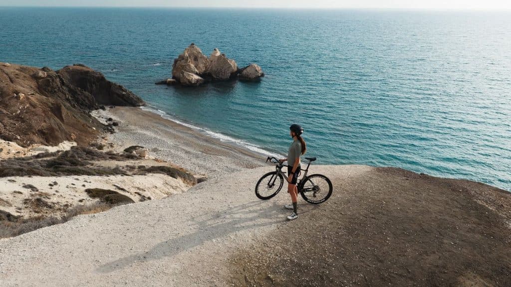 Cyclist overlooking the ocean during a ride, symbolizing structured cycling workouts that complement a consistent cardio routine.